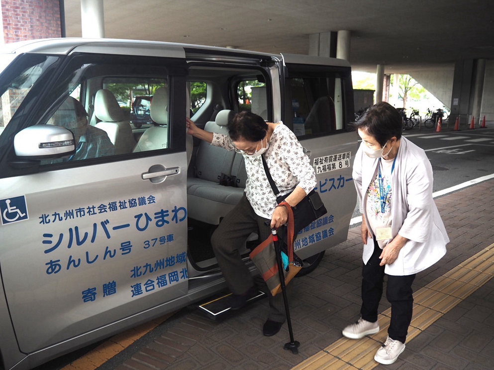 車椅子の高齢者を車に乗せる写真